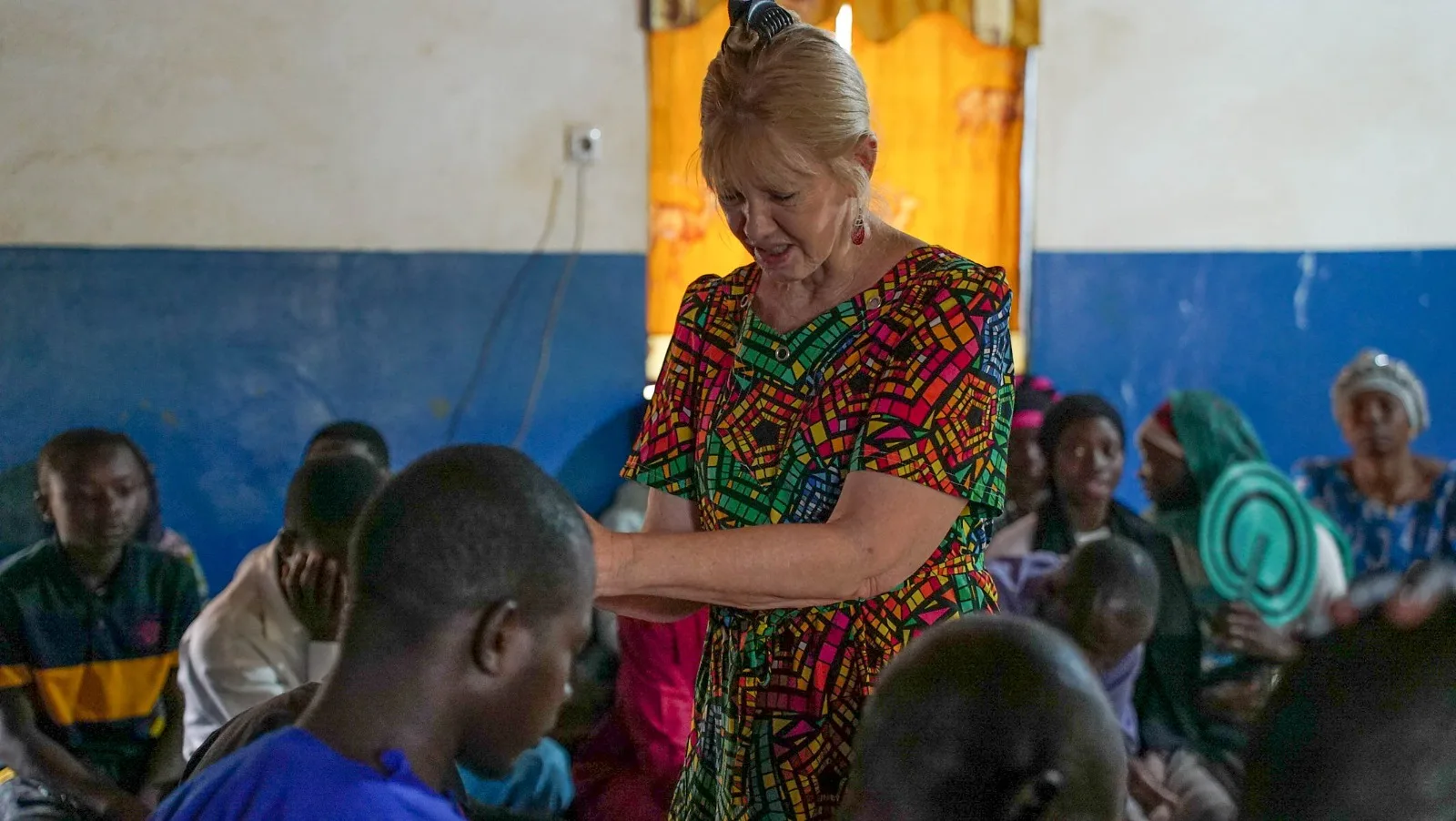 Carole Ward, Founder of Favor International, praying with believers in the field