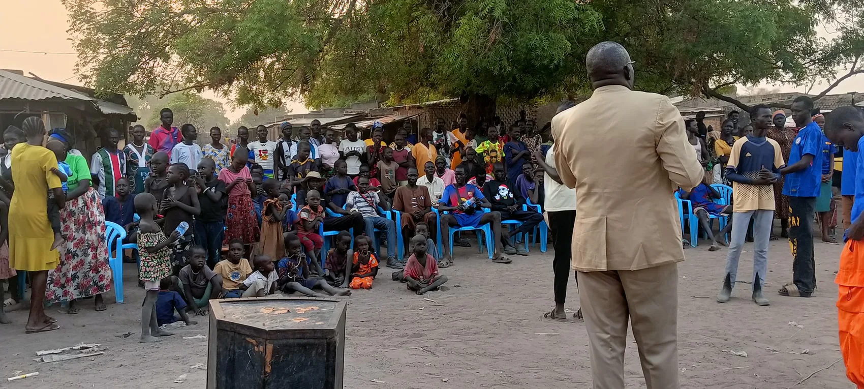 A Favor leader addressing a gathered village community